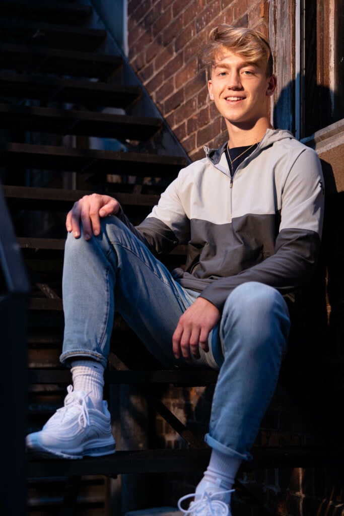 high school senior posing in downtown La Crosse alleyway with cinematic flash lighting — J.L. Wiswell Photography