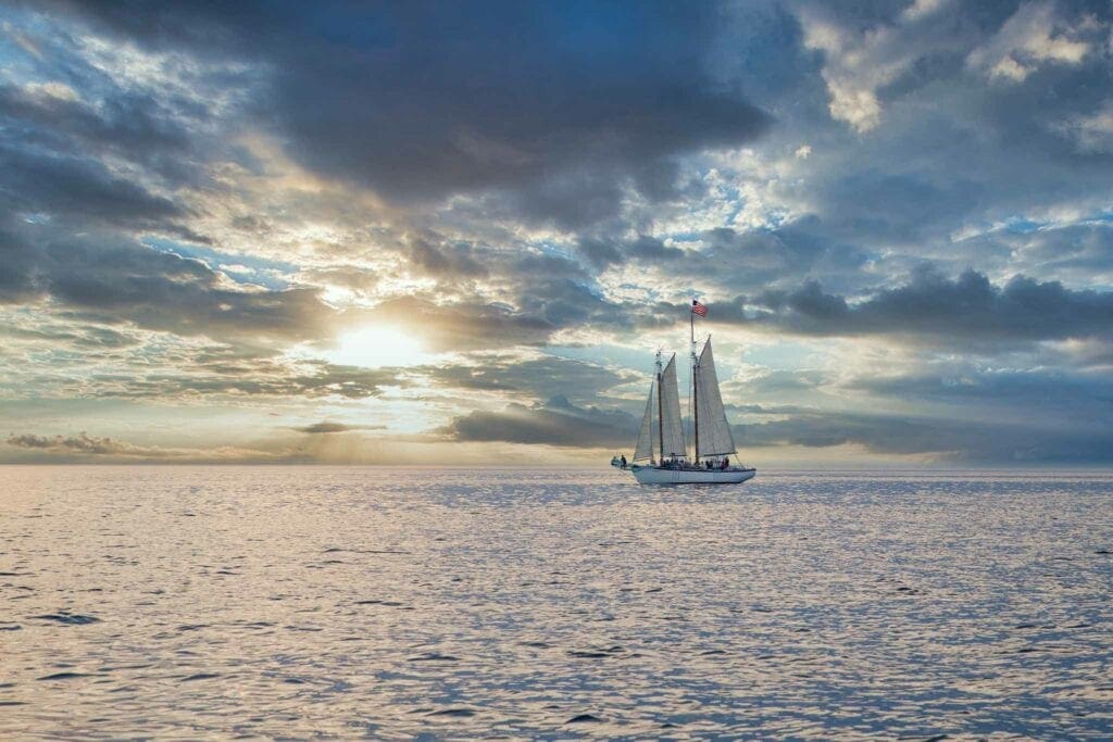 A two-masted schooner on calm water at sunset off Door County