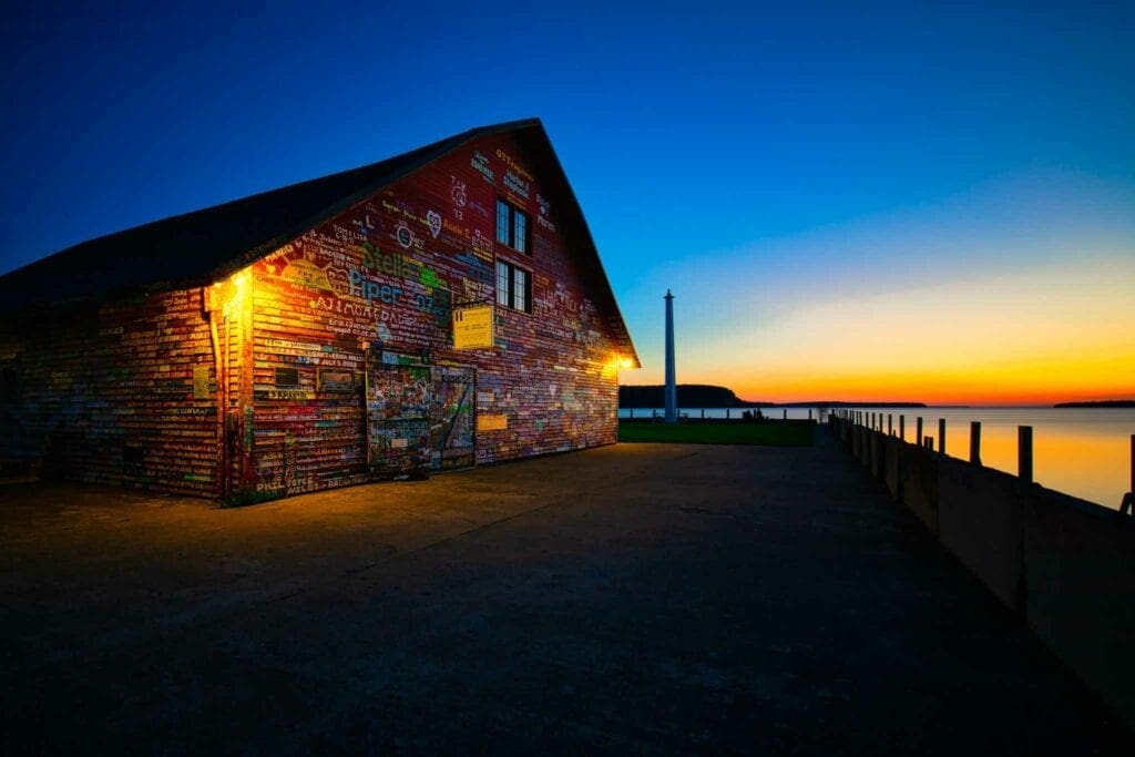 The Anderson Dock warehouse lit warm against a blue-hour sky over the water at Ephraim