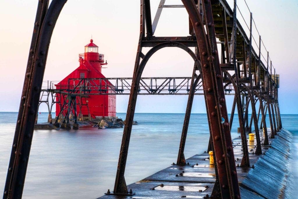 The red pierhead light framed through the weathered steel catwalk at dusk, Sturgeon Bay