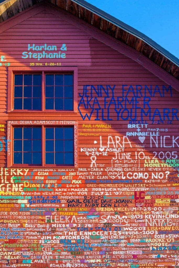 The Anderson Dock wall in Ephraim, covered in names painted by boaters and couples