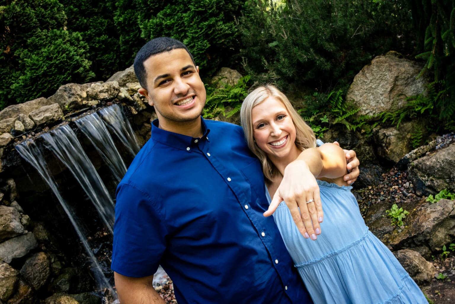A newly engaged couple showing the ring beside the waterfall in the International Friendship Gardens, La Crosse