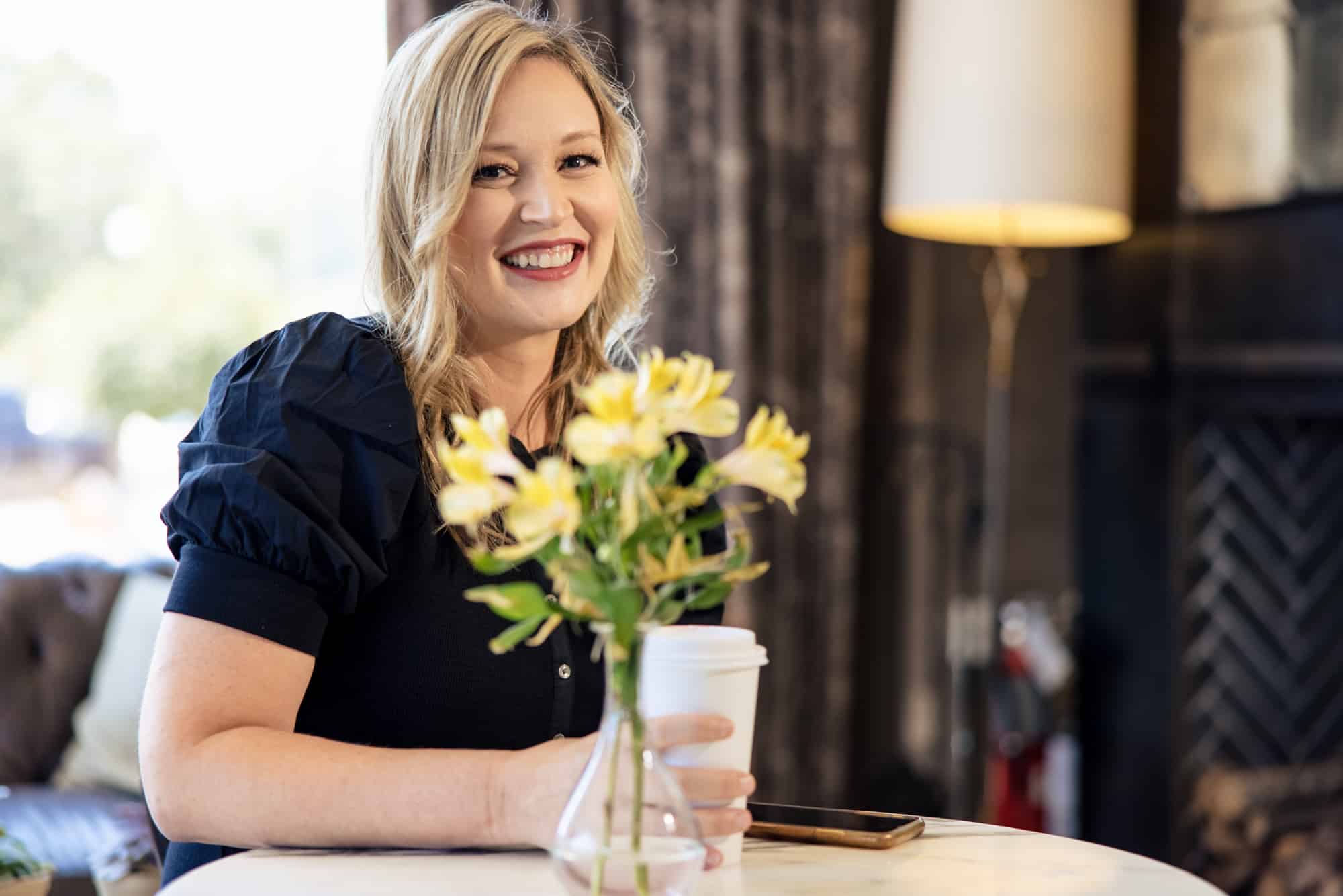 Close, smiling, flowers in the foreground