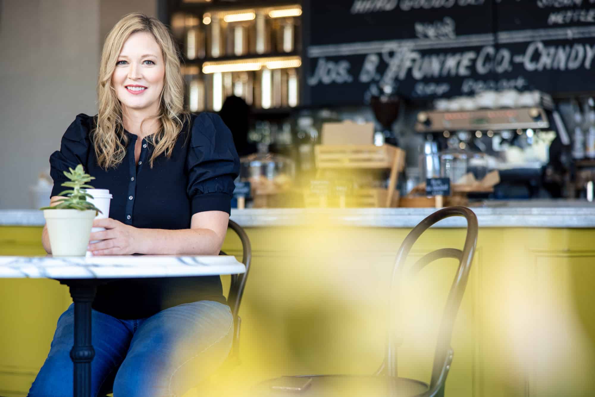 At the yellow table, wider frame