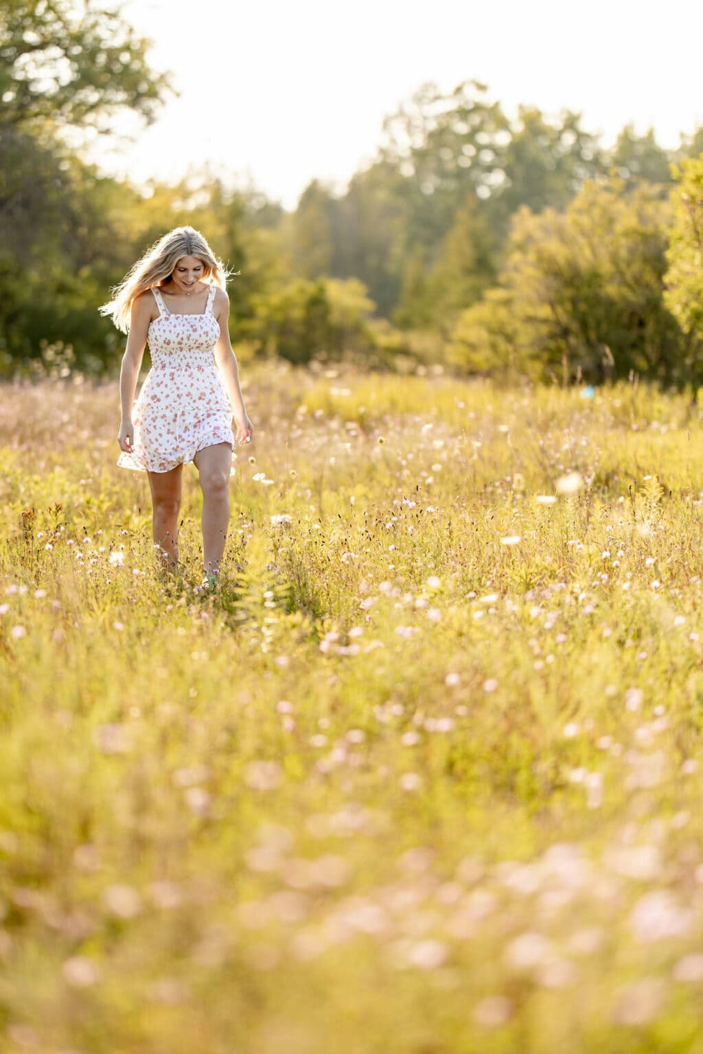 Kaitlyn walking through a field of wildflowers at golden hour