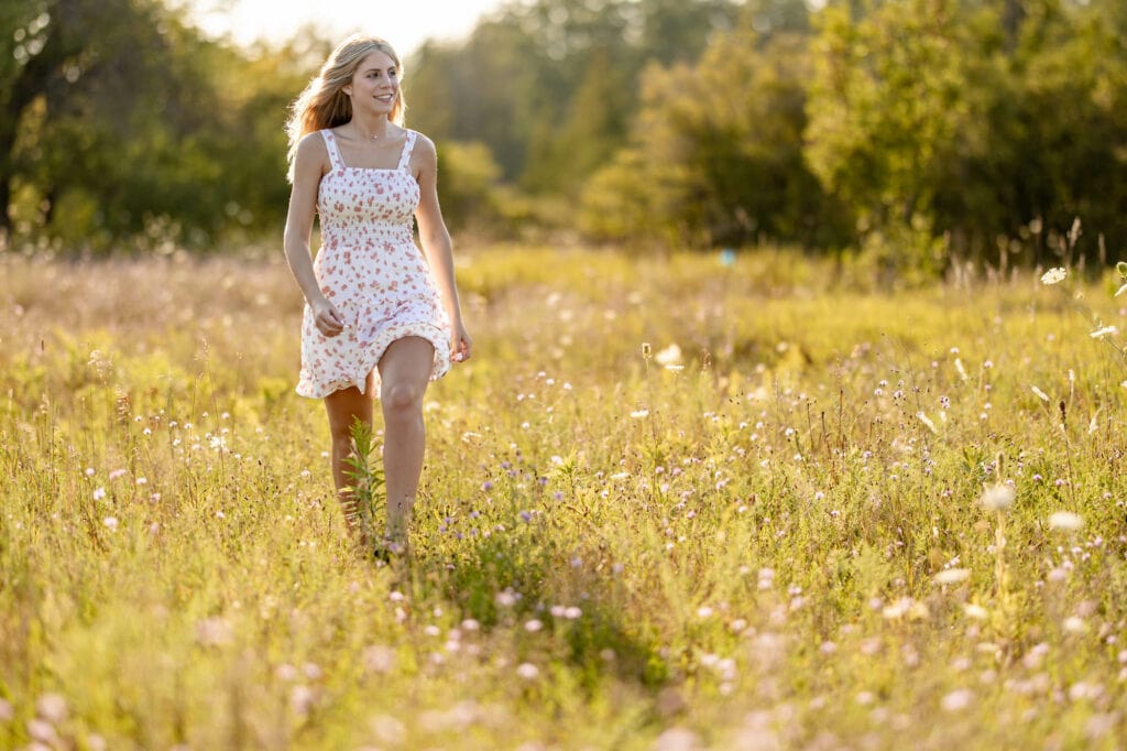 Kaitlyn walking through a field of wildflowers at golden hour