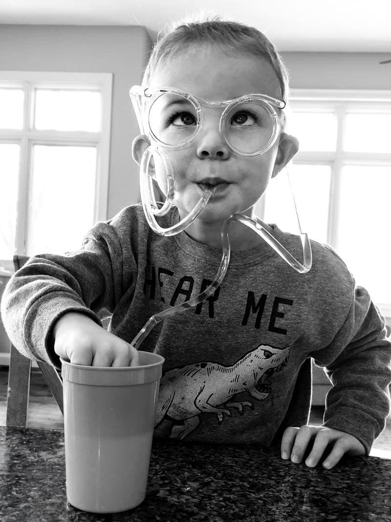Liam drinking through a pair of loopy glasses