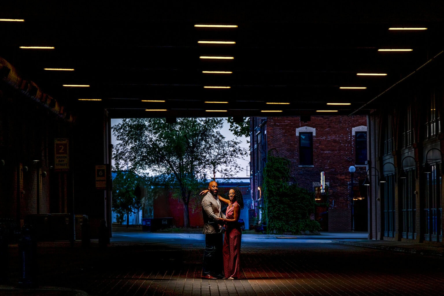 A couple silhouetted under a single light in a downtown La Crosse alley