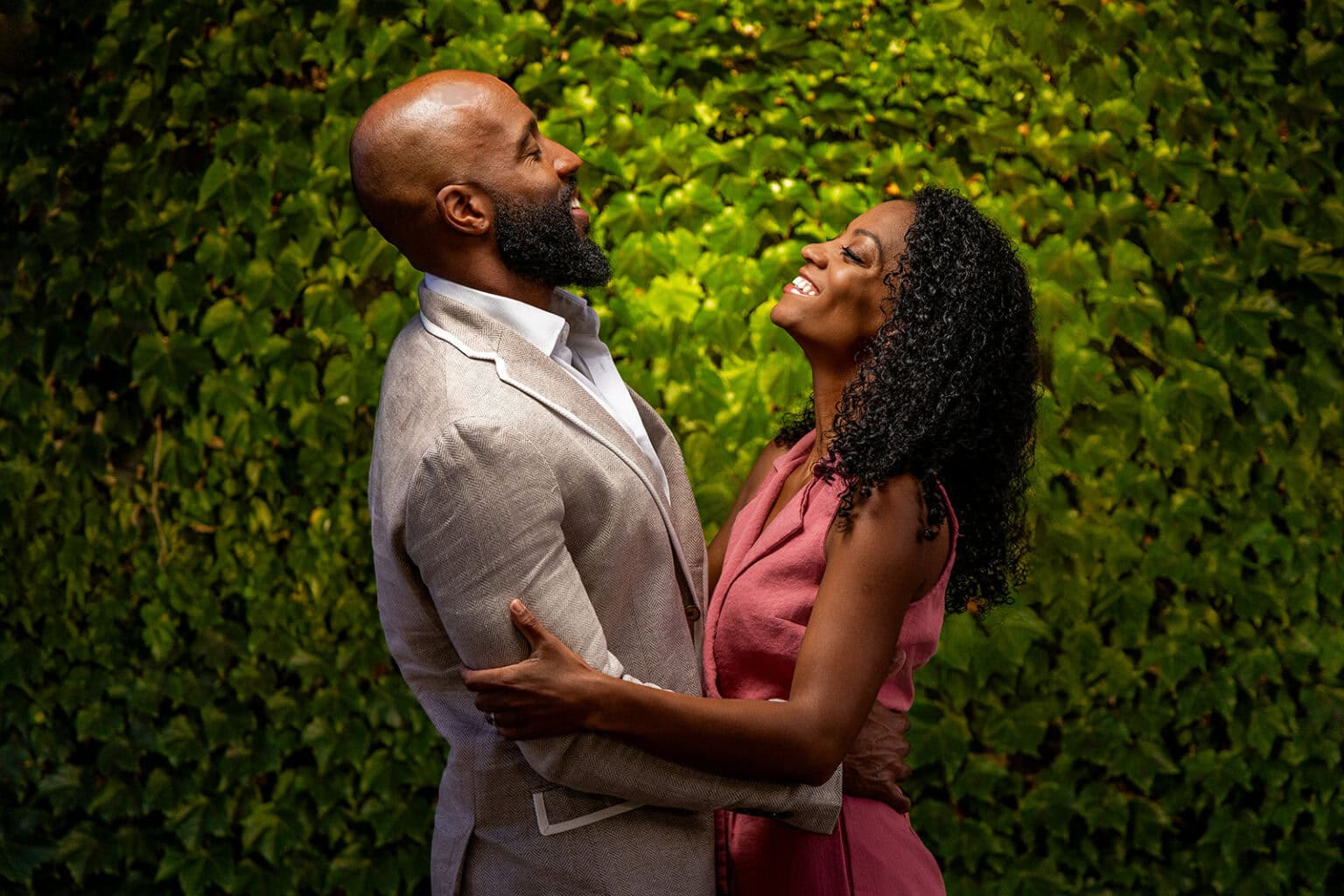 A couple against a lit ivy wall in downtown La Crosse