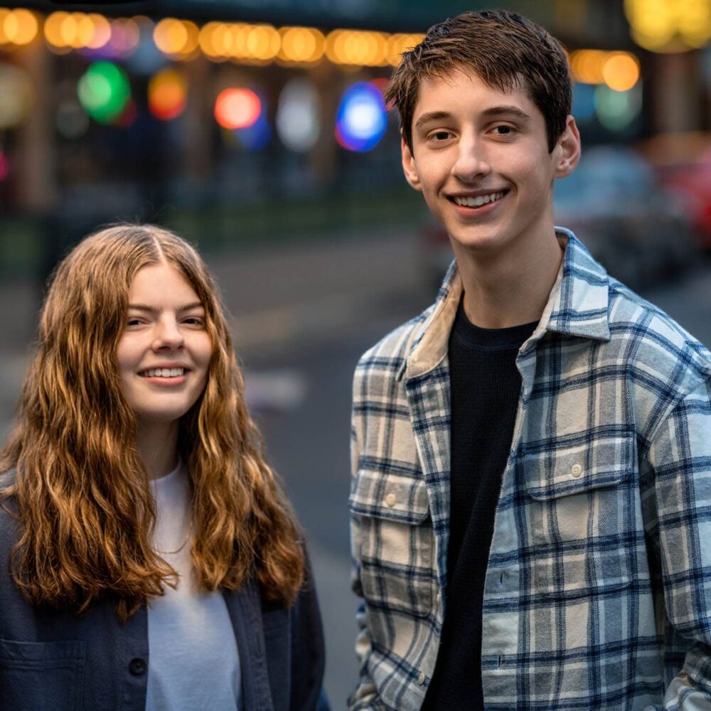 Brooklyn and Danny on a lit downtown street
