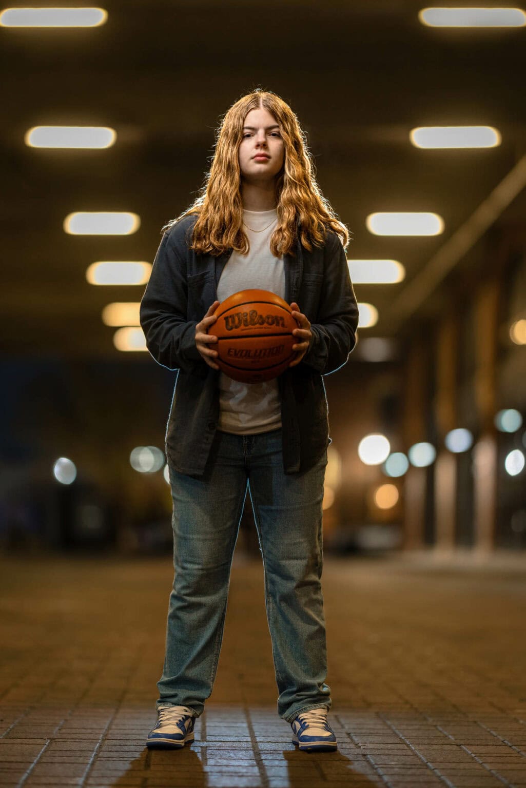 High school senior holding a basketball in a La Crosse parking garage