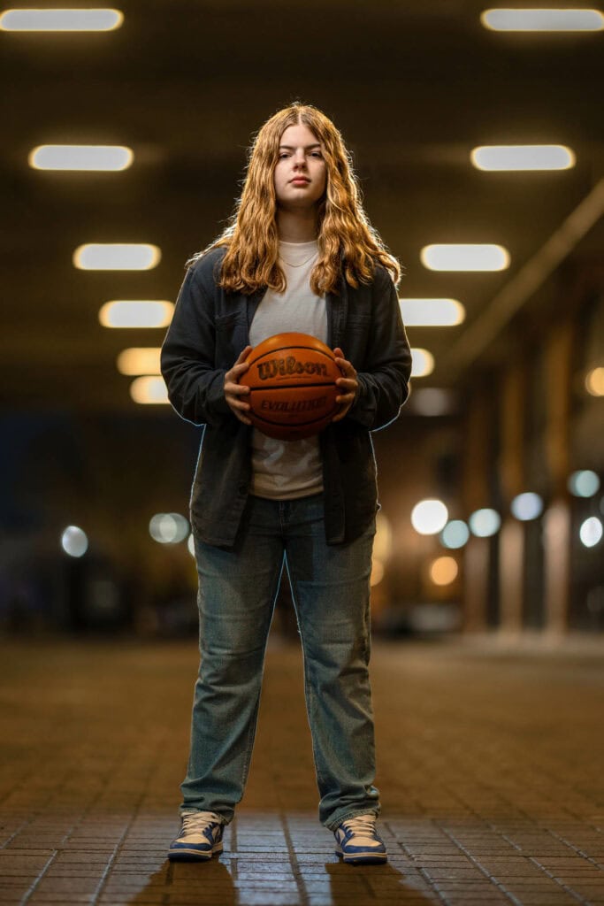 Brooklyn with a basketball under the lights of a downtown La Crosse parking garage