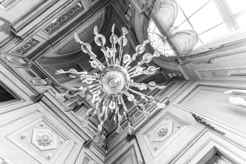 A crystal chandelier hanging from an elaborate coffered ceiling, Florence