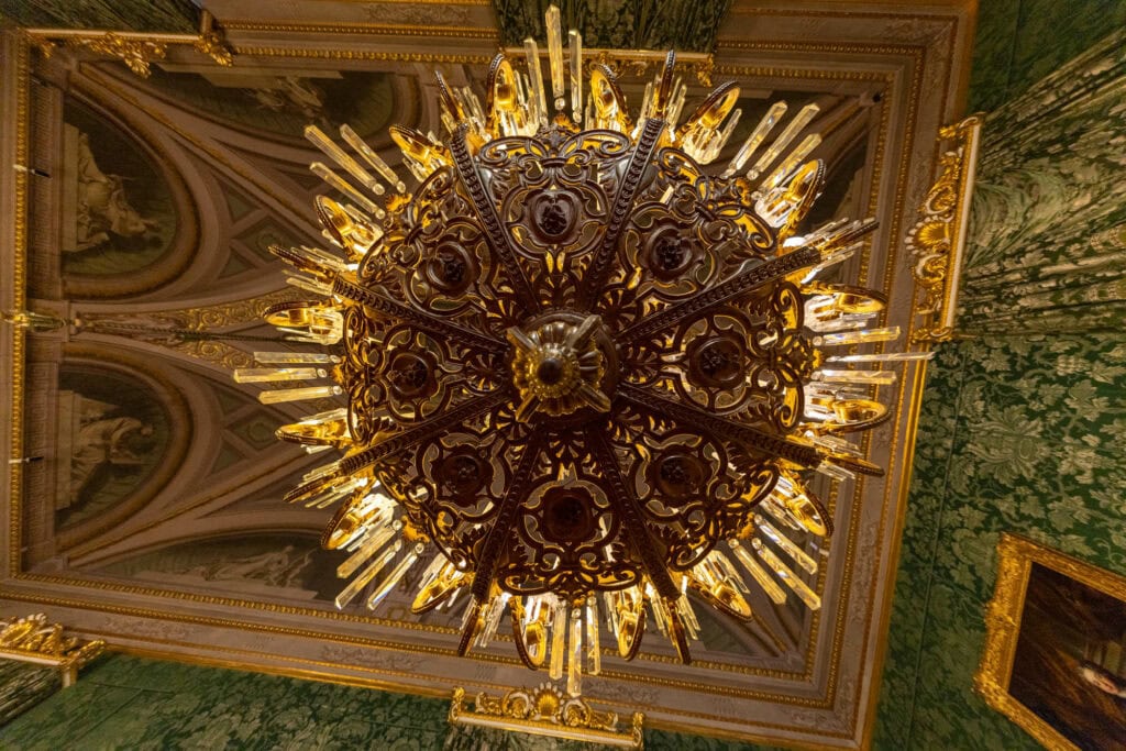 Ornate gilt ceiling with baroque chandelier and intricate gold detailing, Florence, Italy