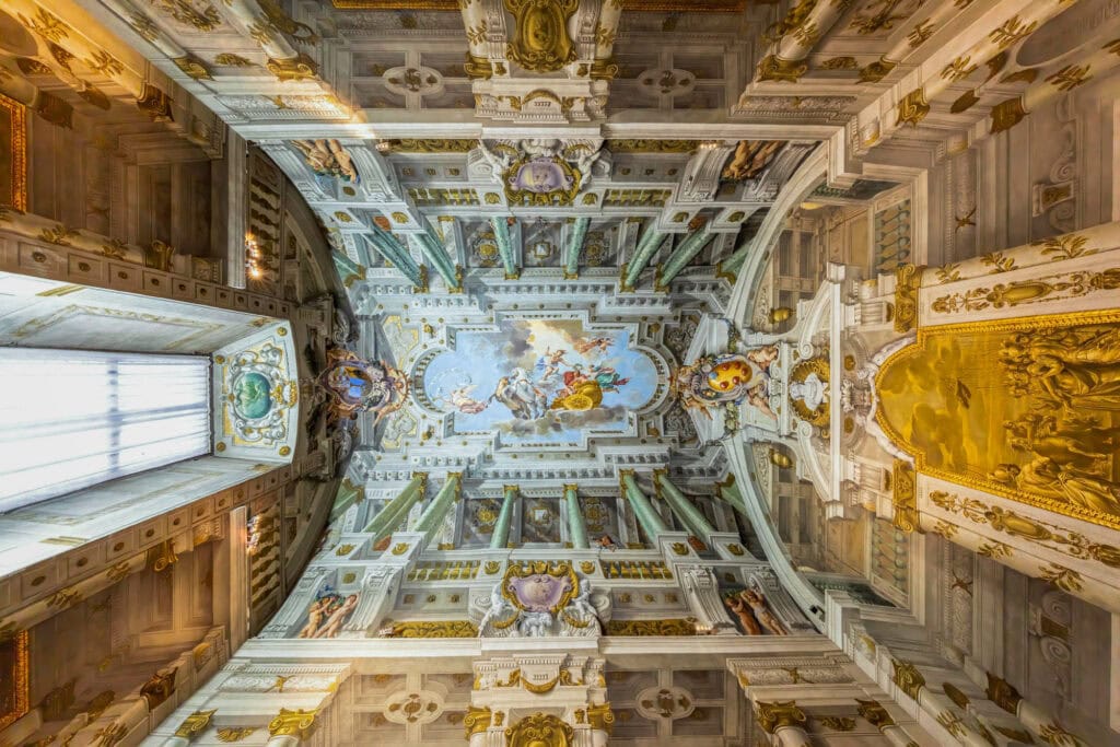 Ornate Renaissance ceiling with frescoed vaults, gilded details, and classical religious imagery in Florence, Italy