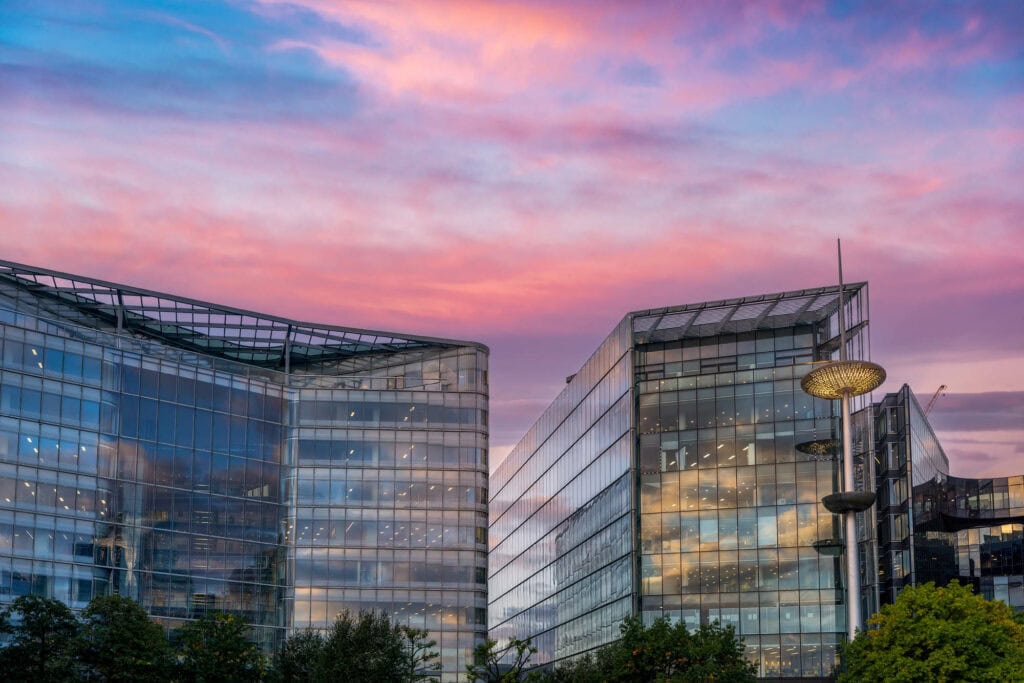 Modern glass office buildings at dusk with pink and purple sky, London or Florence travel photography