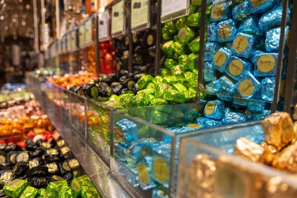 Colorful spice and dried goods displayed in bulk bins at a European market stall, Florence