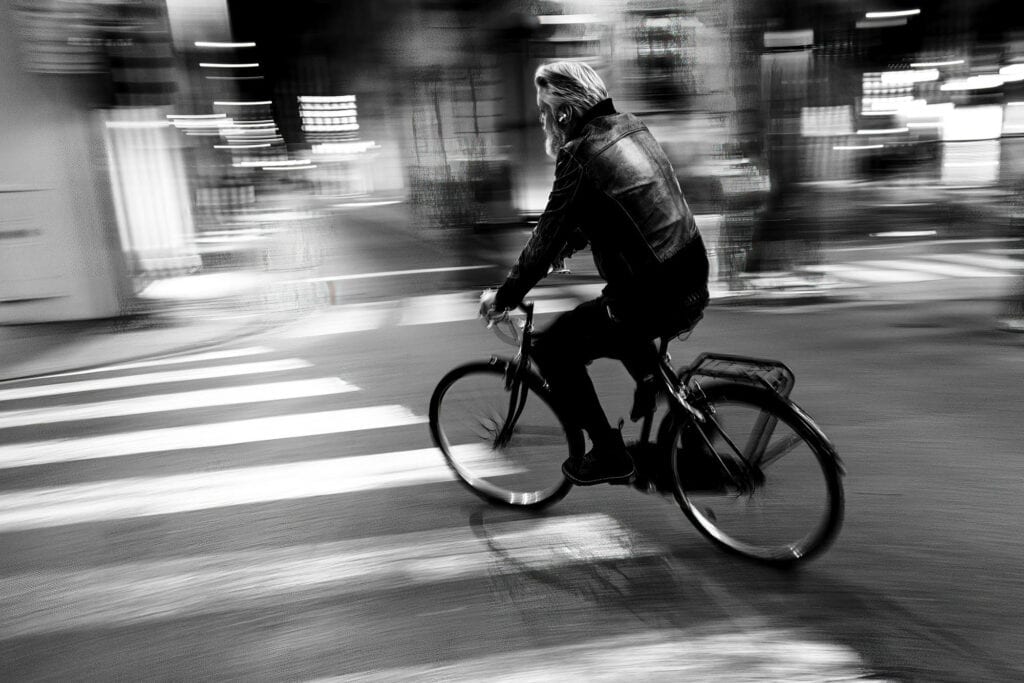 A cyclist in motion blur through a Florence street, shot at a slow shutter speed