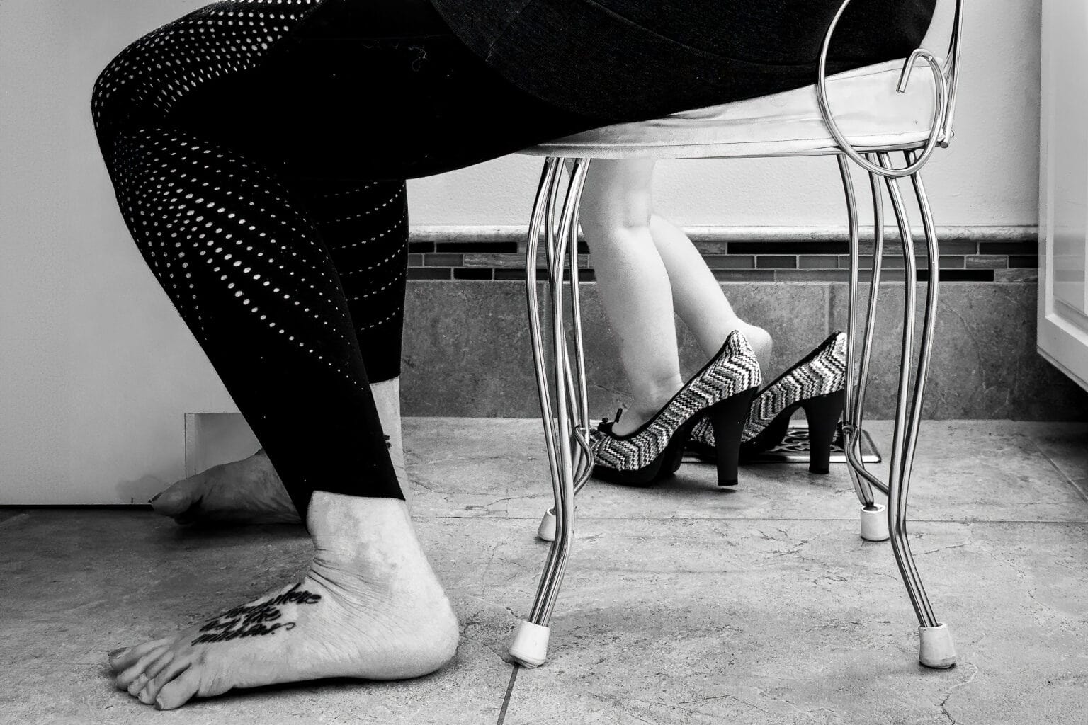 Black and white study of small feet in heeled shoes