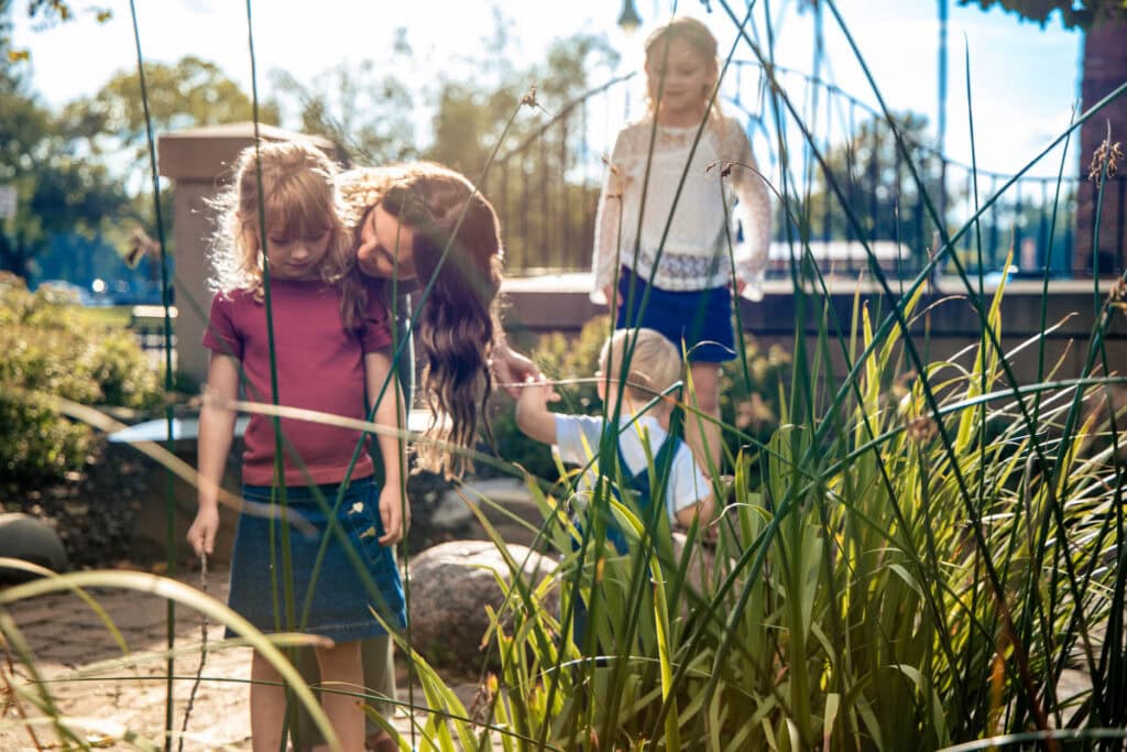 Family walking a stone path through the garden at the start of their session
