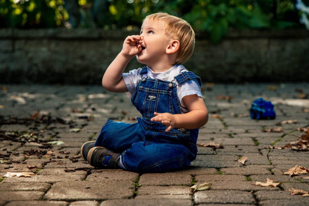 Close-up of two children side by side, the tree canopy soft in the background