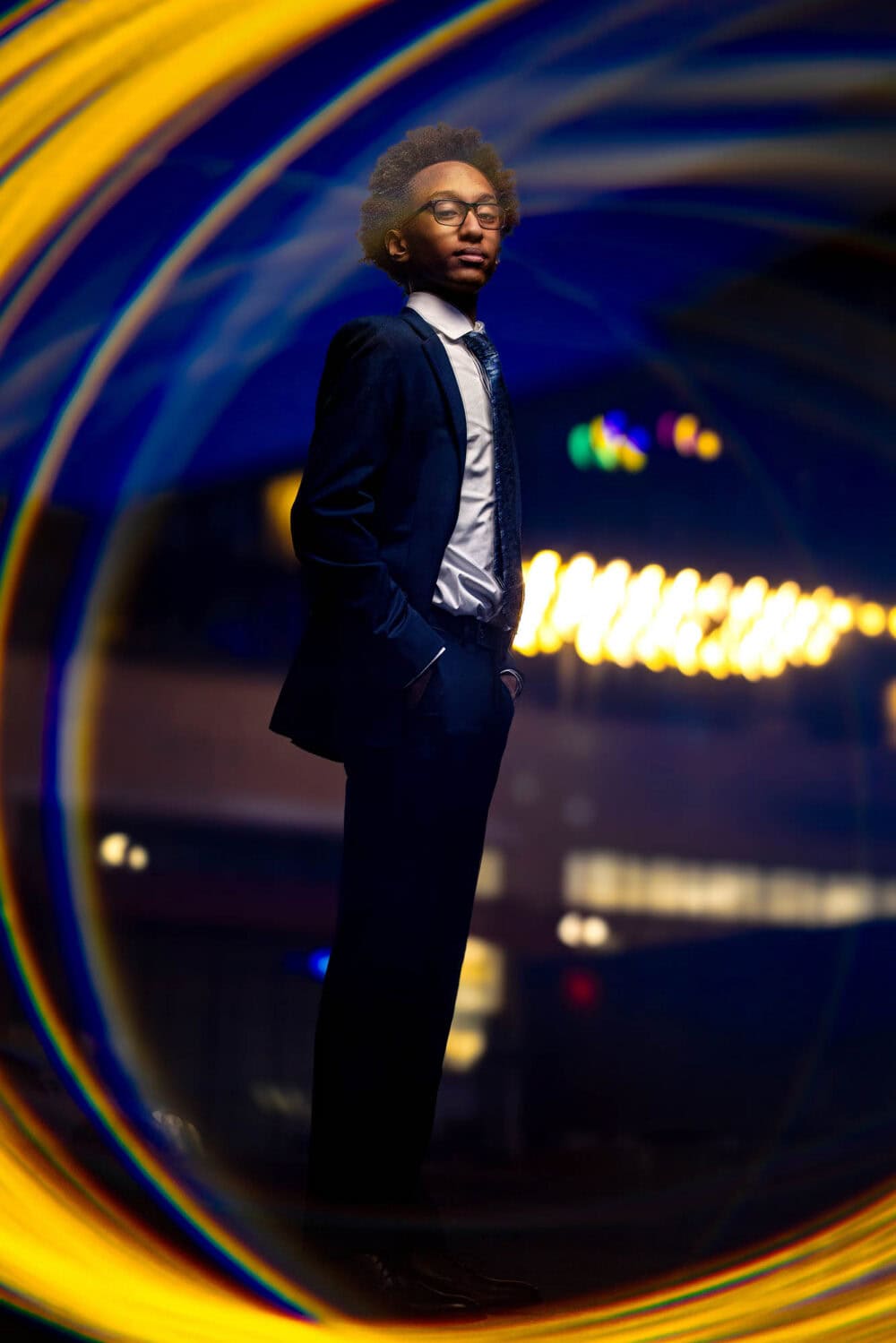Kaleb in a navy suit framed by golden light downtown