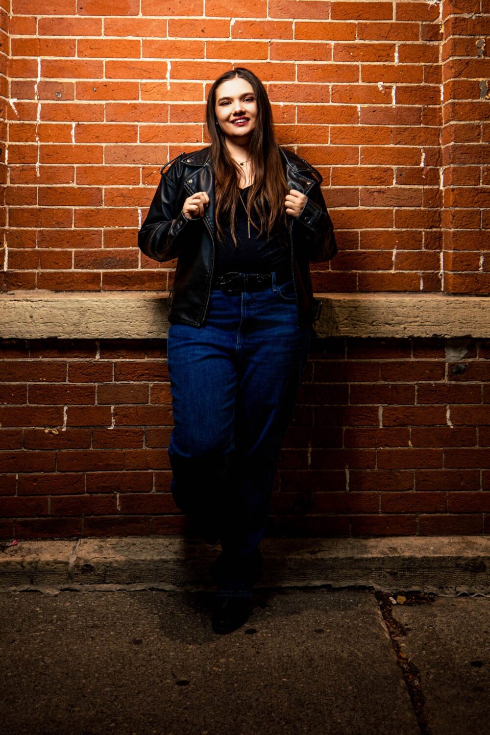 Claire against a brick wall downtown La Crosse
