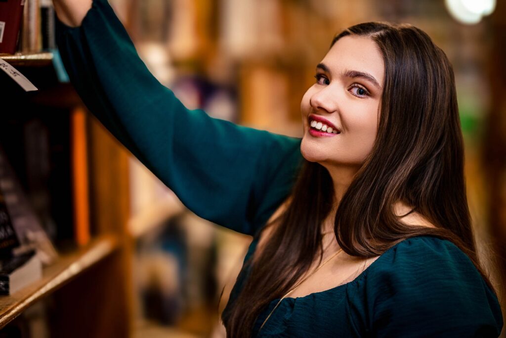 Claire reaching for a shelf at Pearl Street Books