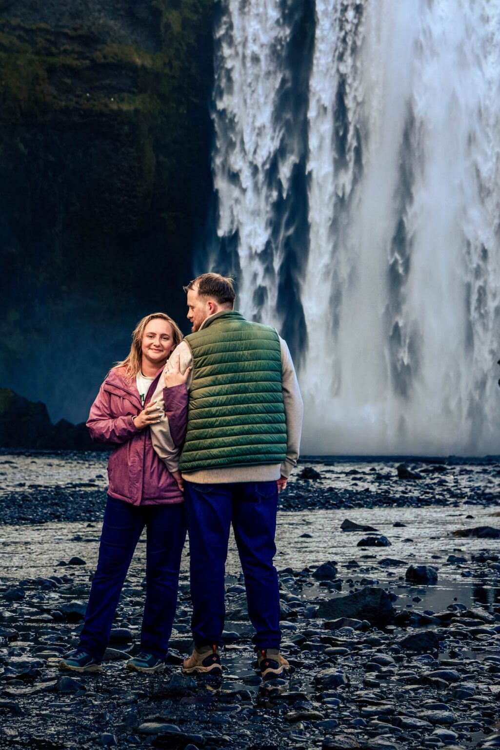 A newly engaged couple at the foot of Skogafoss waterfall, Iceland