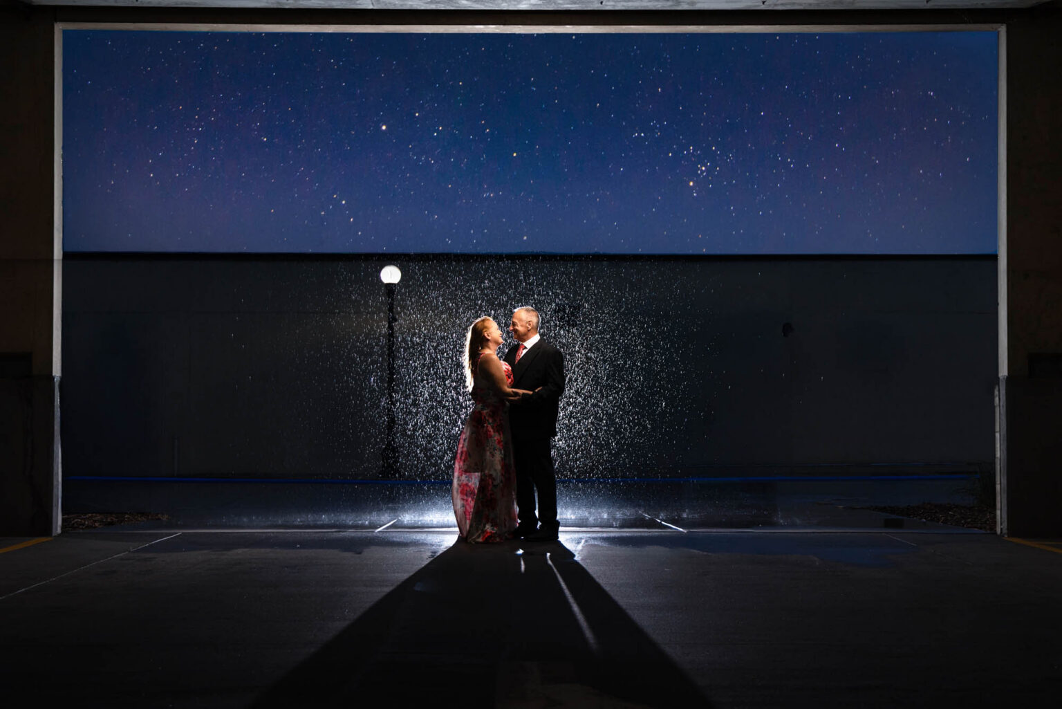A couple dancing in the rain under a single streetlight at night