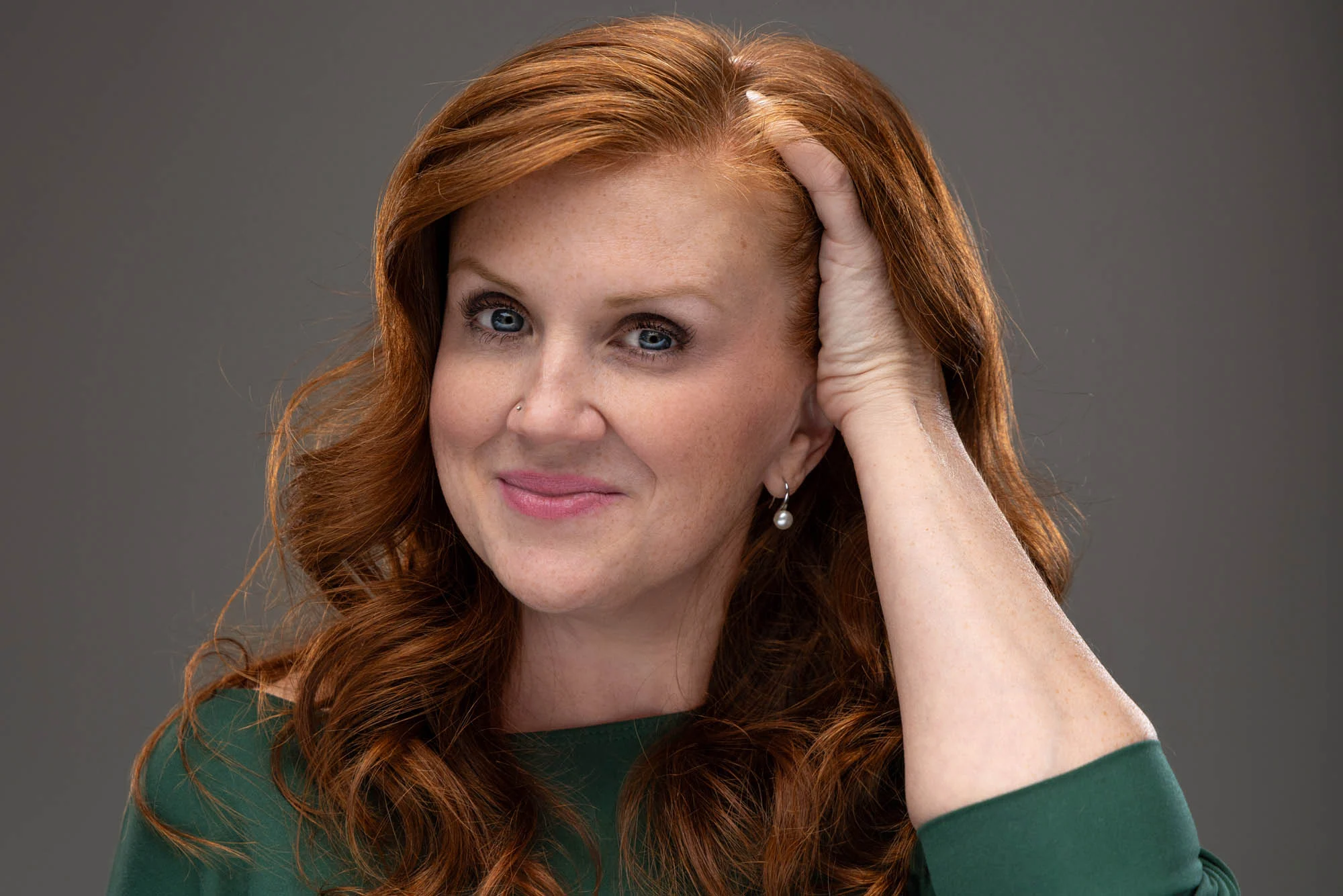 Studio headshot of a woman against a grey backdrop