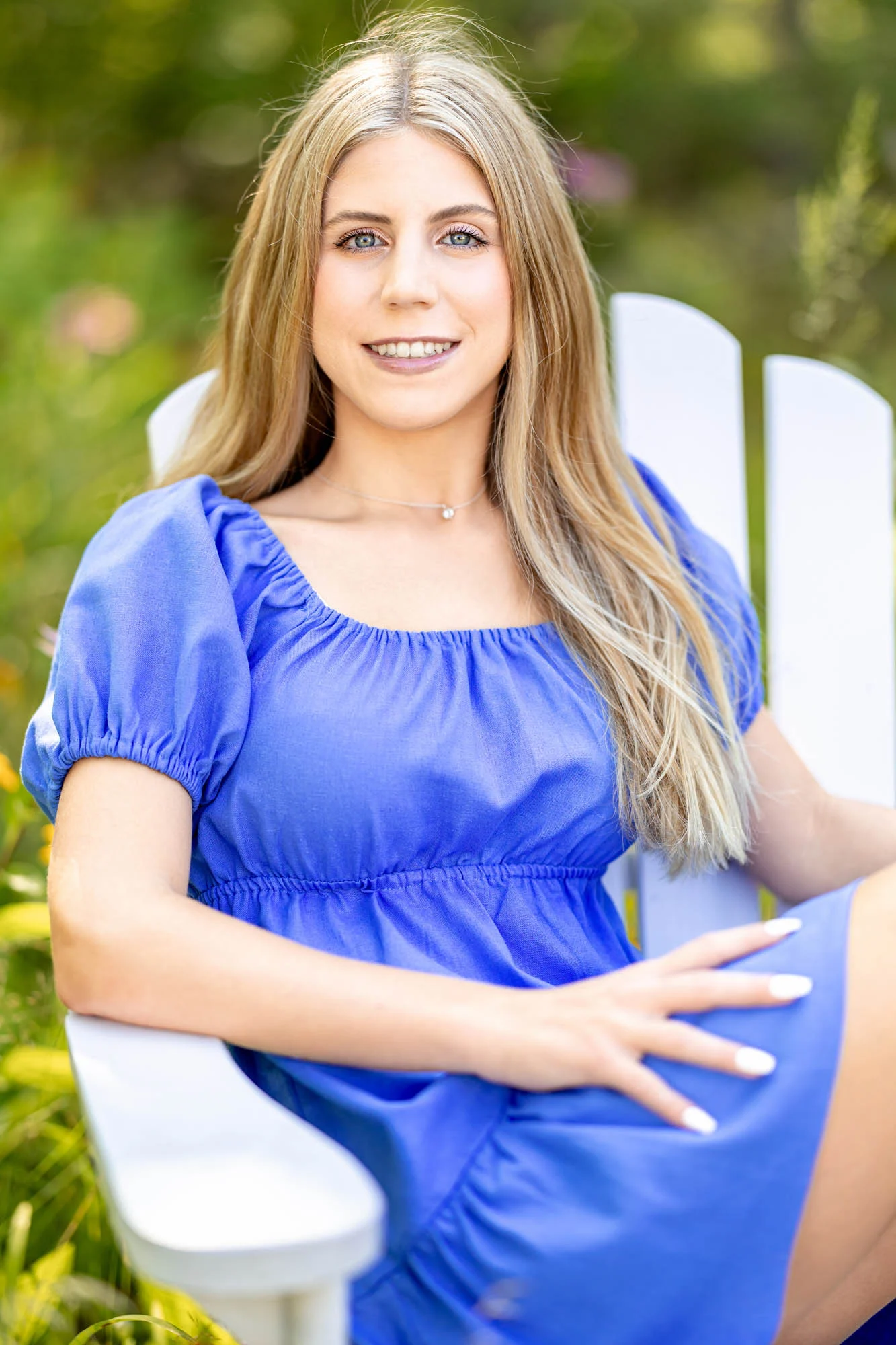 High school senior in a blue dress seated outdoors, La Crosse WI