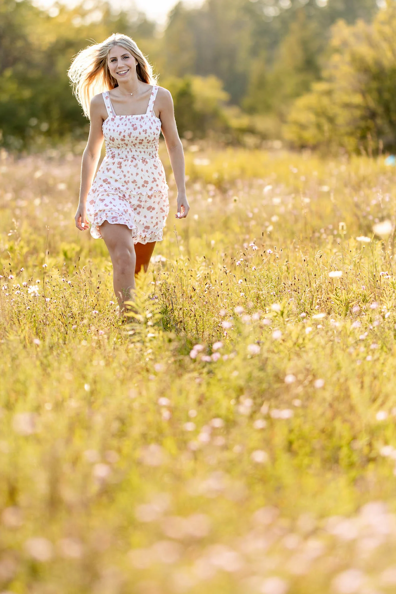 High school senior walking a sunlit wildflower meadow at golden hour, La Crosse WI