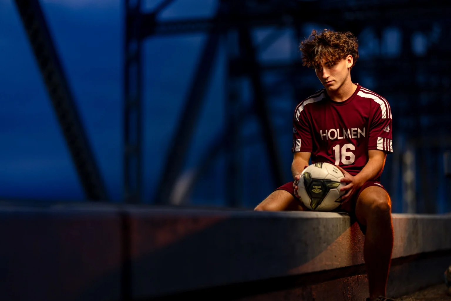 Deacon in his Holmen soccer jersey on the Cass Street Bridge at dusk