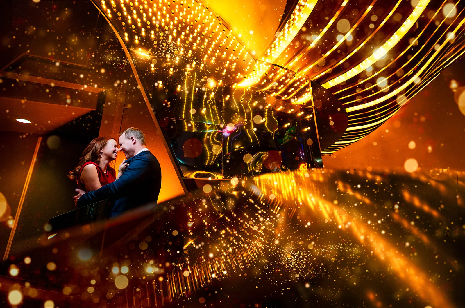 Jeff and Alisha Wiswell on the stairs under the Fremont Street canopy, Las Vegas, light trails swirling around them. Photo by Chris Benavides, CH Photography (ch-photographer.com).