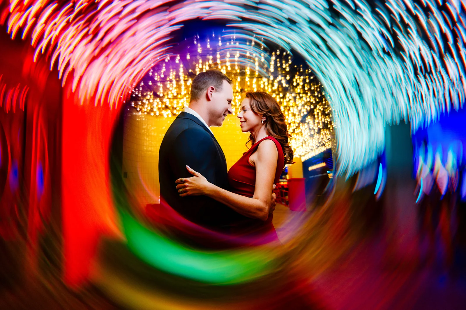 Jeff and Alisha Wiswell holding each other inside a radial burst of light trails, Fremont Street, Las Vegas. Photo by Chris Benavides, CH Photography (ch-photographer.com).