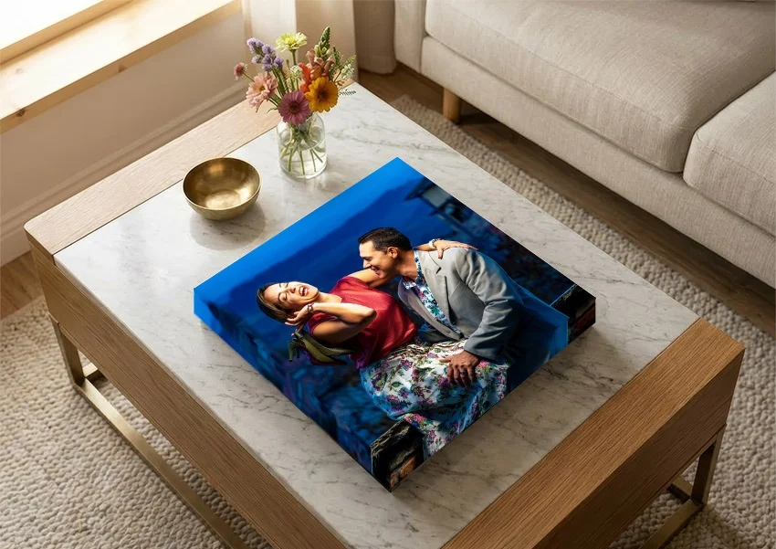 An album with a couple’s portrait wrapped over its cover, on a marble coffee table