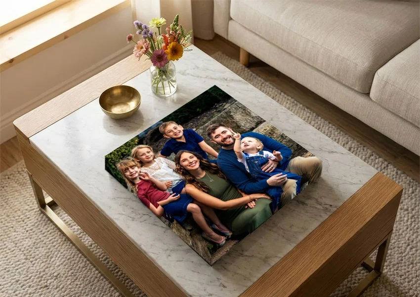 A family album with a family portrait wrapped over its cover, on a marble coffee table