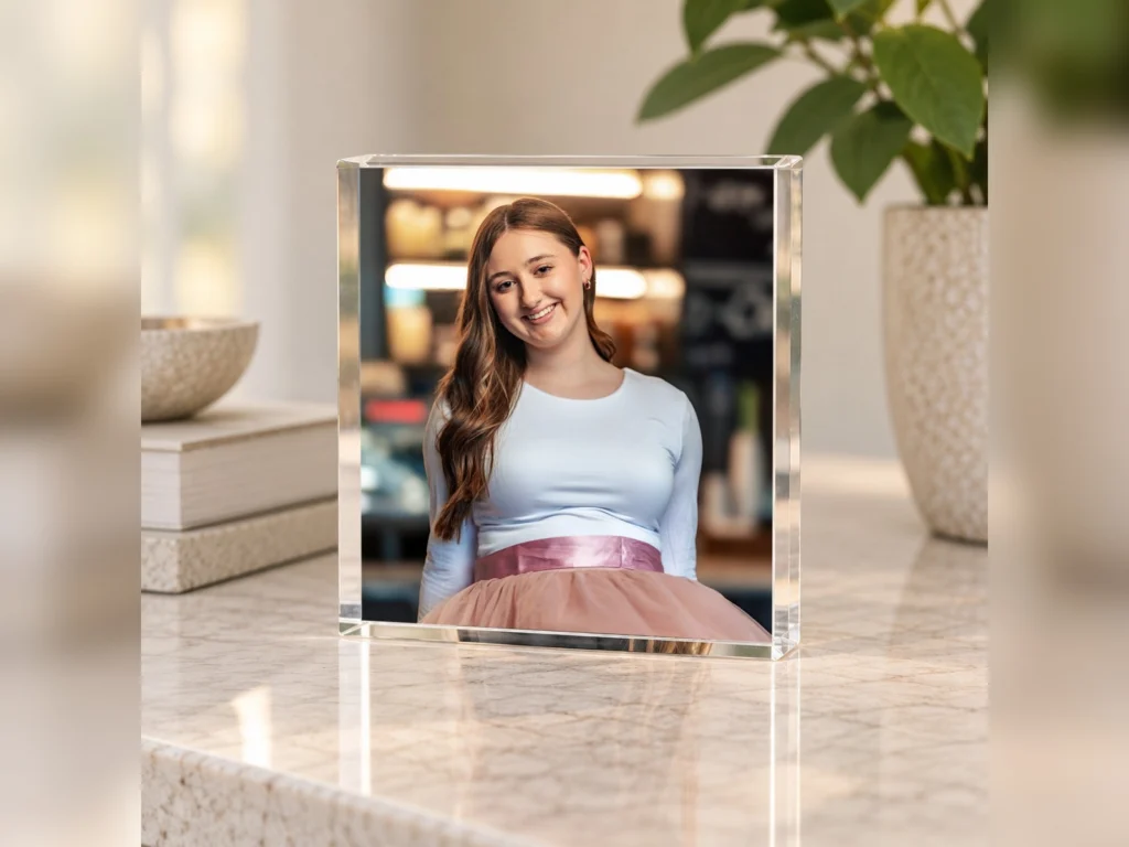 An acrylic block print of a high school senior on a marble counter