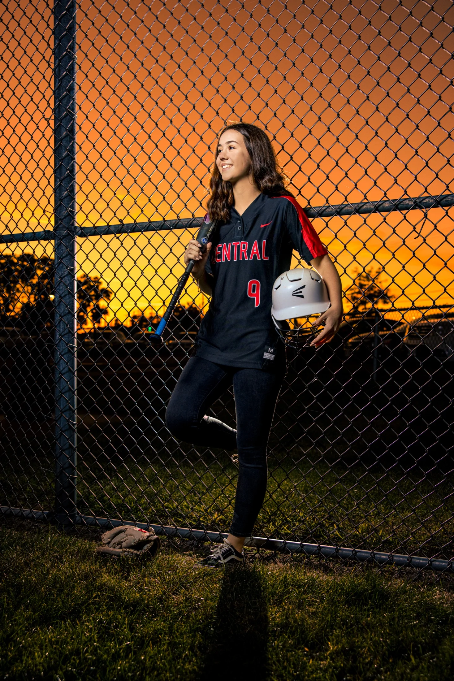 Award-winning senior portrait: a softball player at the fence at sunset, by J.L. Wiswell Photography